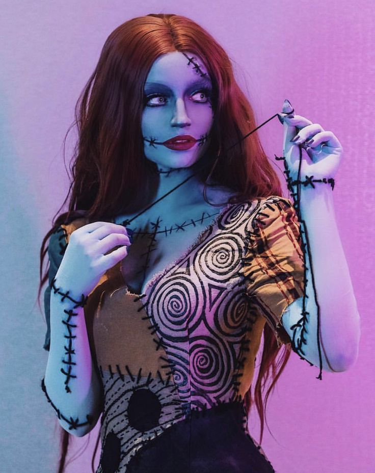 a woman with makeup painted to look like she is holding something in her hand and looking at the camera