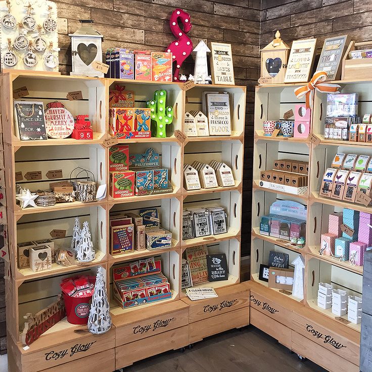 two wooden shelves filled with lots of different types of cards and gifts on display in a store