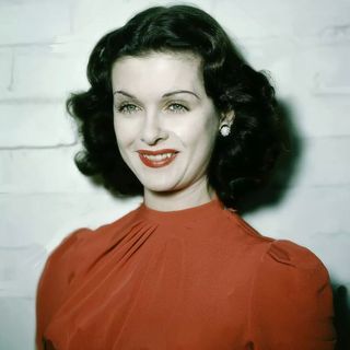 an old photo of a woman with dark hair and red dress smiling at the camera