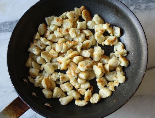 some food is cooking in a frying pan on the stove top and ready to be cooked