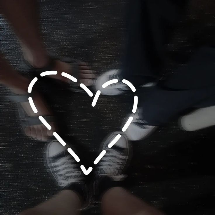 two people standing next to each other holding hands in front of a heart shaped outline