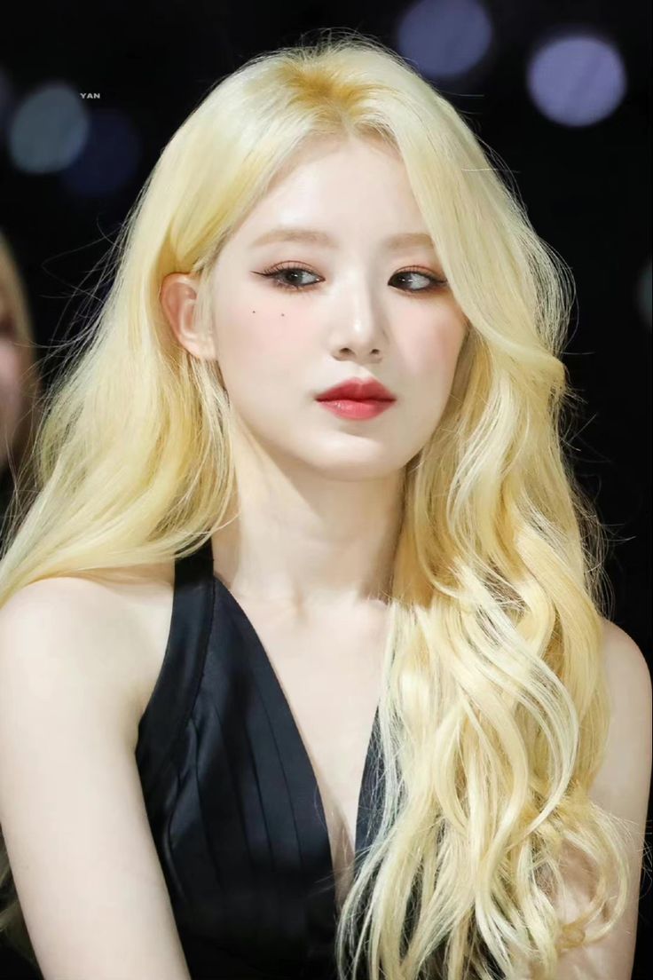 a woman with long blonde hair wearing a black dress