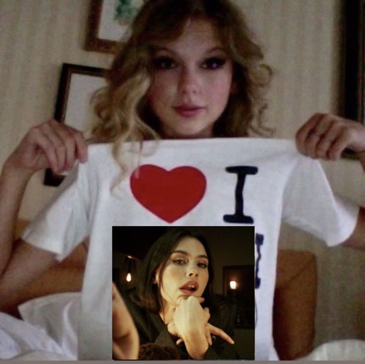 a woman holding up a t - shirt with an i heart on it