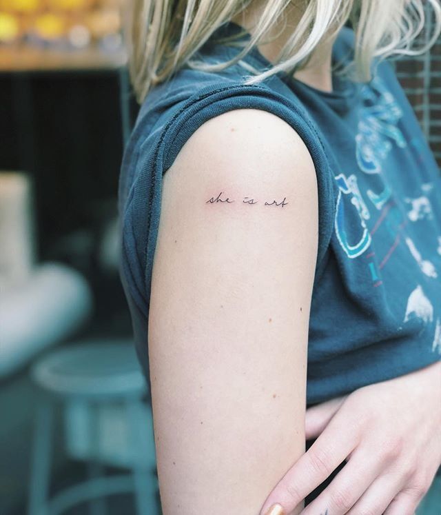 a woman with a small tattoo on her left arm and the word love is written in cursive writing