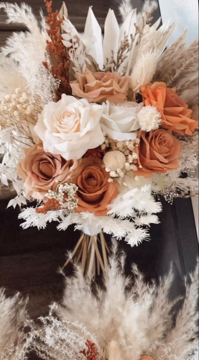 an arrangement of flowers and feathers on display