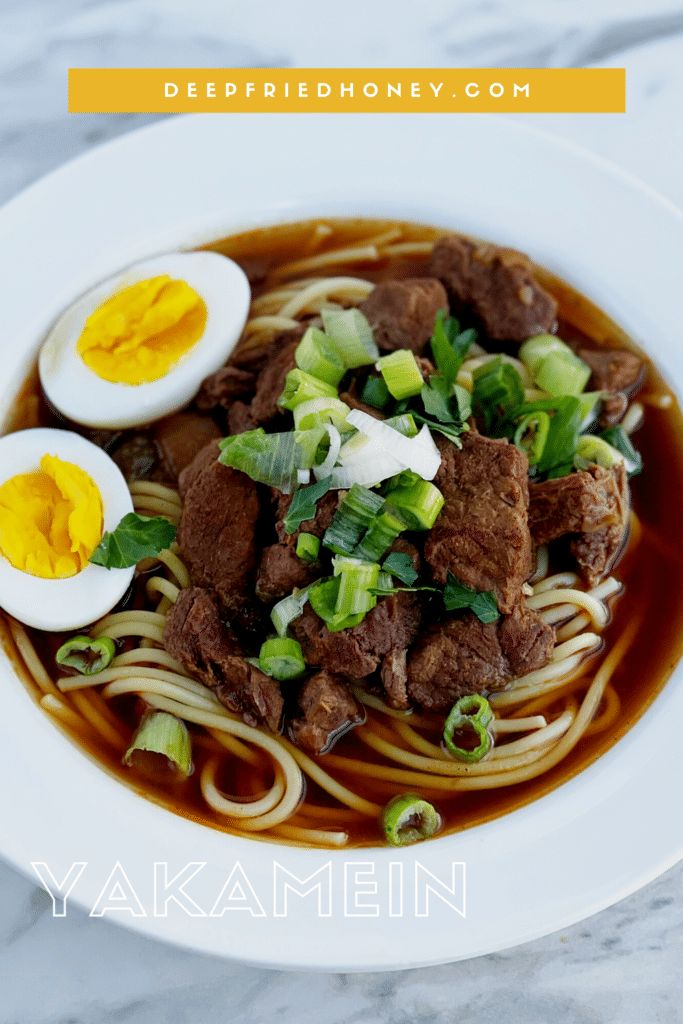 a bowl of beef and noodles with an egg on top