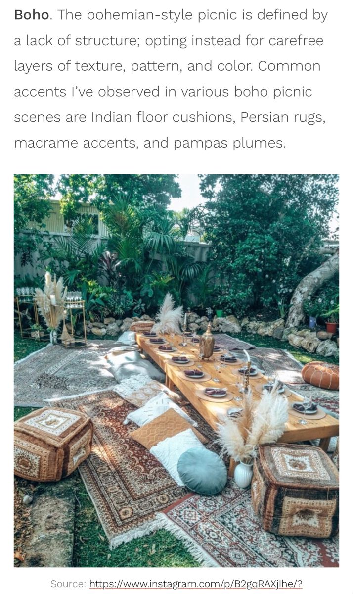 an outdoor dining table with lots of chairs and rugs on the ground in front of trees