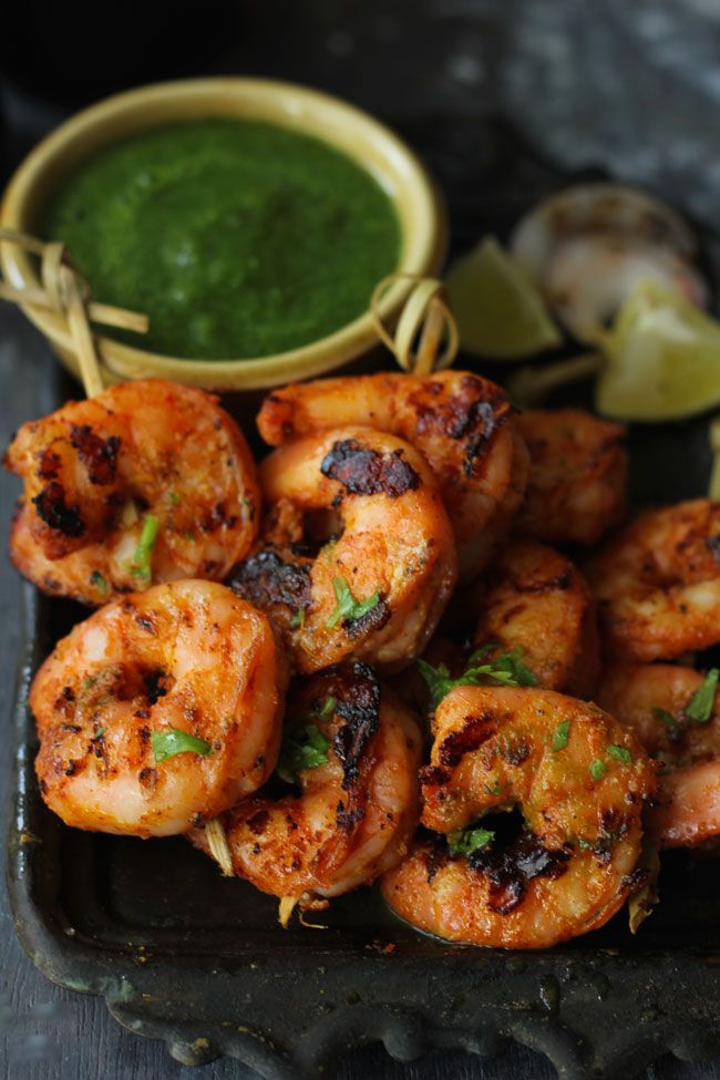 grilled shrimp with green dipping sauce on a plate