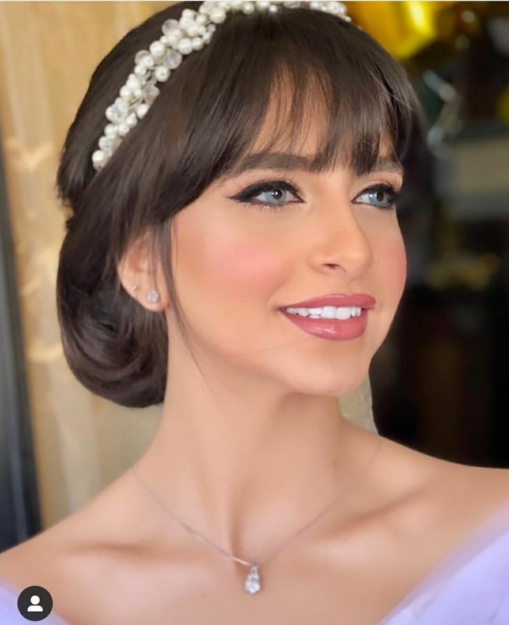 a woman wearing a tiara with pearls on it's head and smiling at the camera