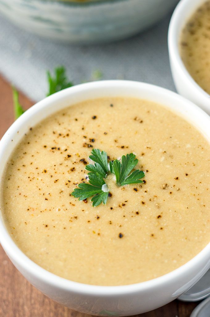 two white bowls filled with soup and garnished with parsley