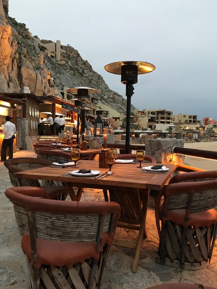 an outdoor dining area with wooden tables and chairs