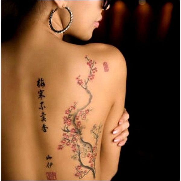 the back of a woman's body with tattoos on it