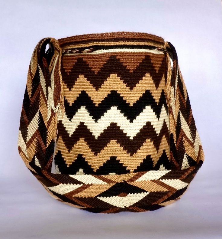 a brown and white woven bag sitting on top of a table