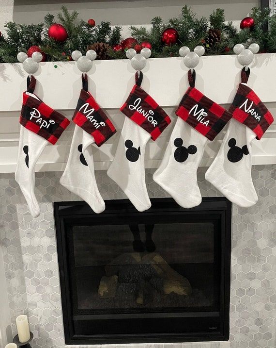 christmas stockings hanging from a fireplace mantel decorated with mickey mouse and minnie mouse stocking