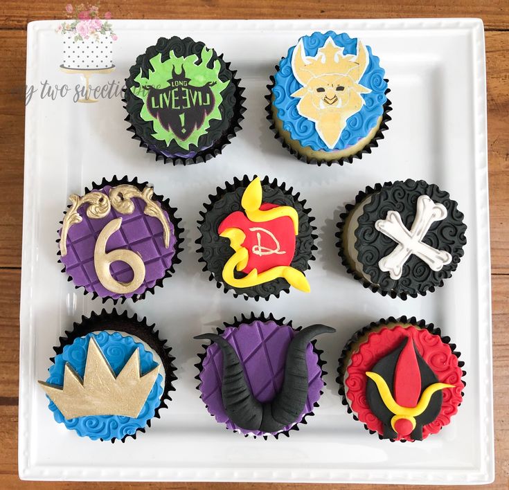 nine decorated cupcakes in the shape of different characters on a white platter