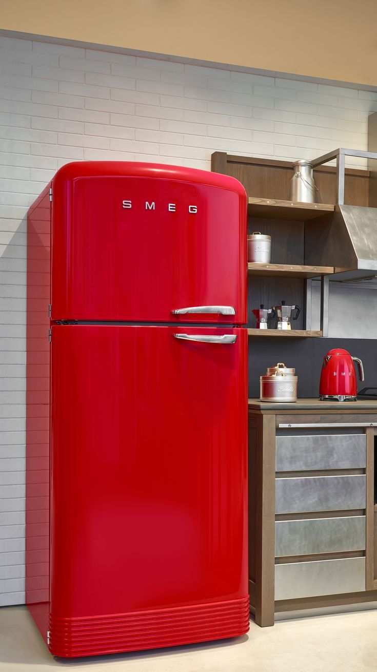 a red refrigerator sitting in the middle of a kitchen