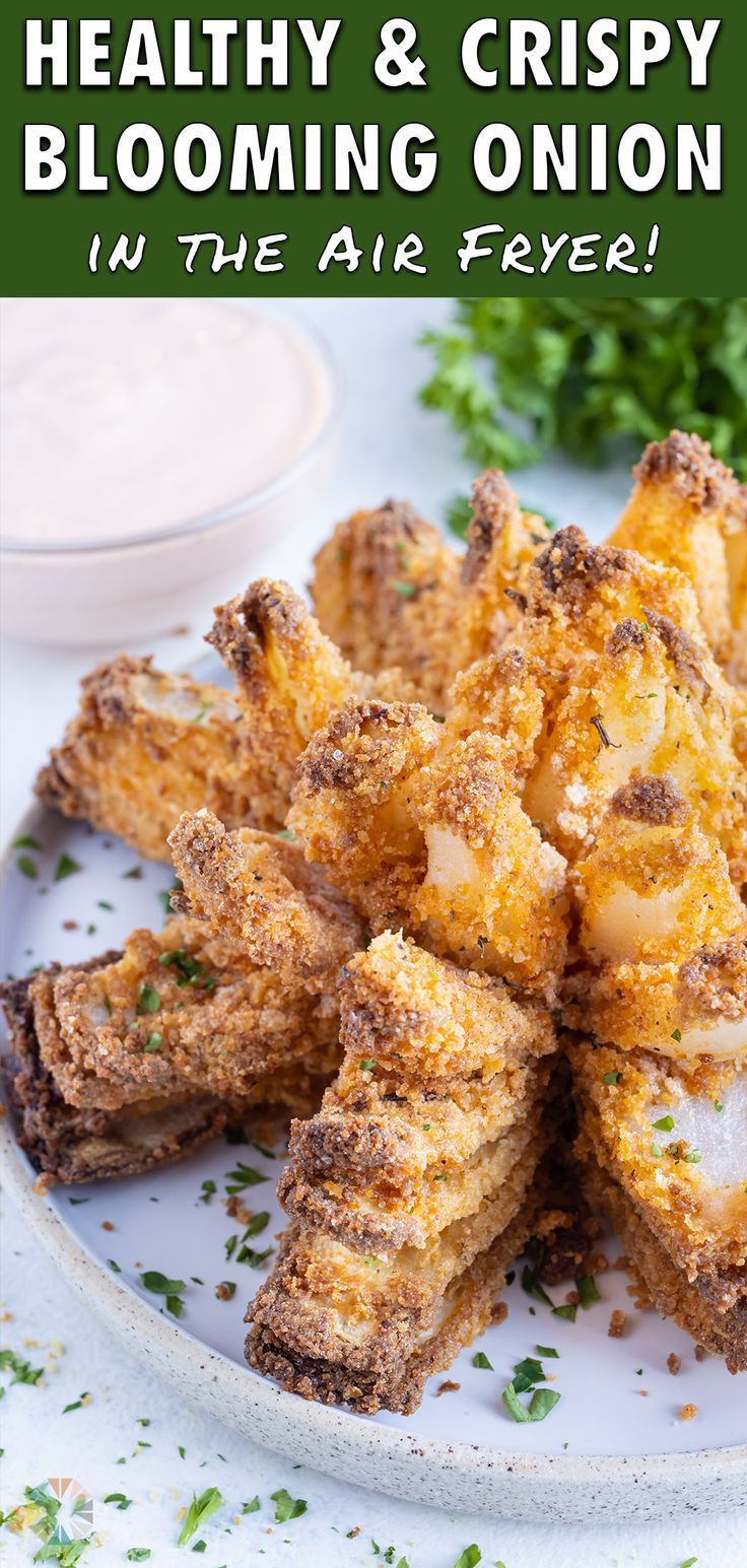 some fried food on a white plate with sauce and parsley in the background text reads healthy & crispy blooming onion in the air fryer