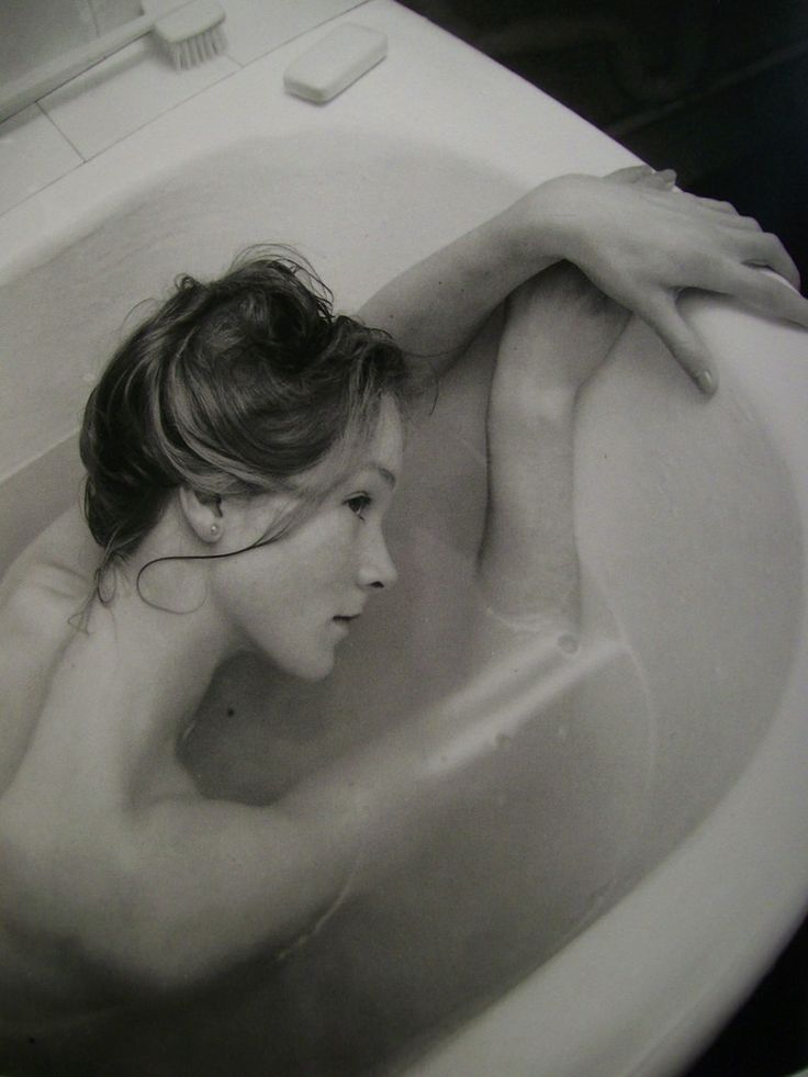 black and white photograph of a woman in a bathtub