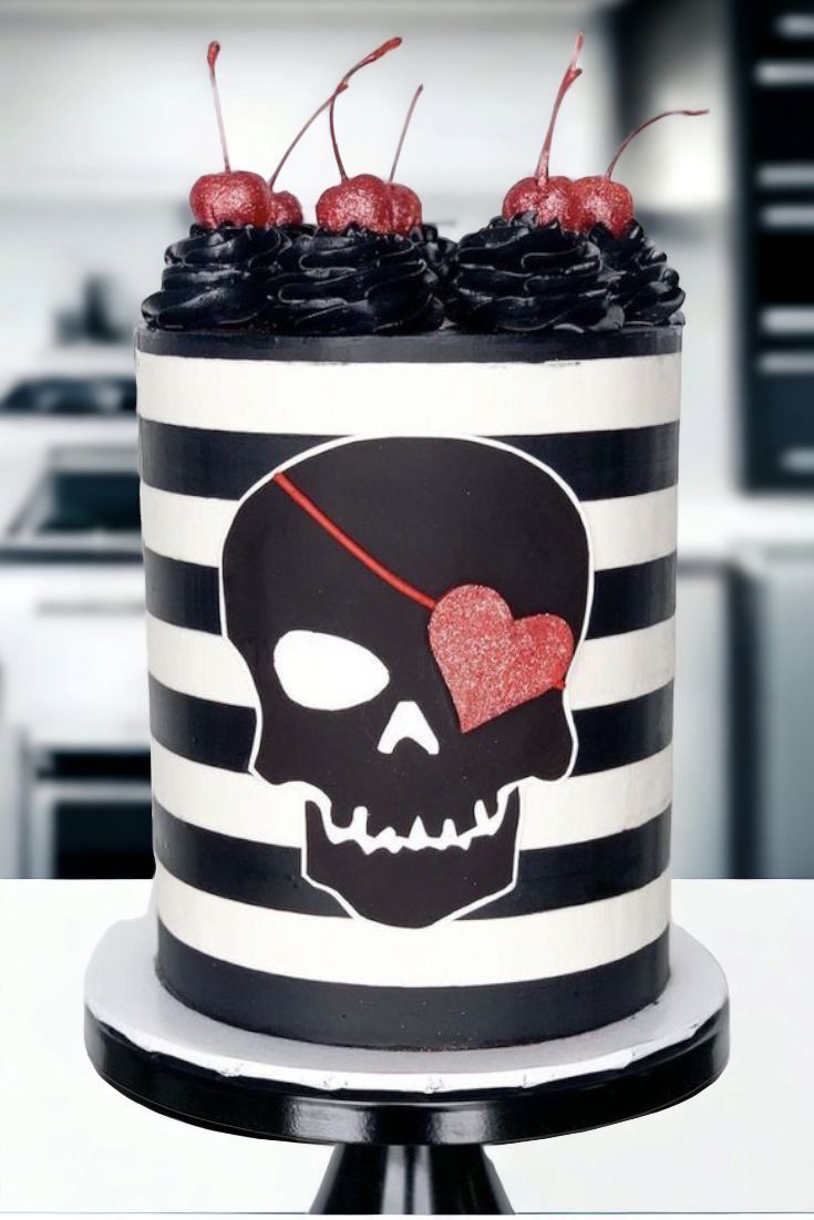 a black and white striped cake with red cherries on top is decorated with a skull