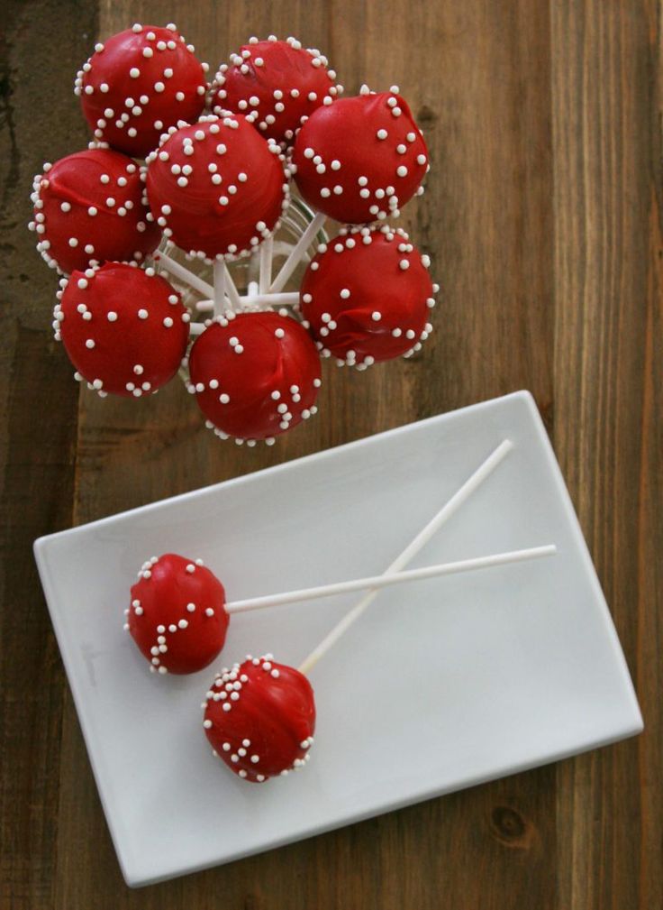 red cake pops with white sprinkles on a plate