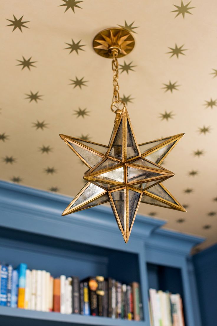 a gold star hanging from the ceiling in a room with blue walls and bookshelves