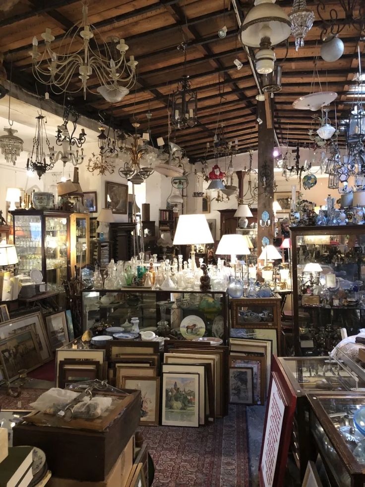 a room filled with lots of different types of lamps and pictures hanging from the ceiling