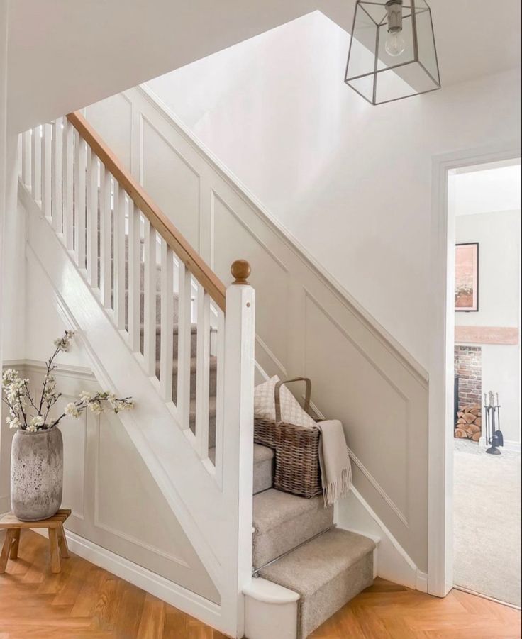 a white staircase with wooden handrails leading up to the second floor