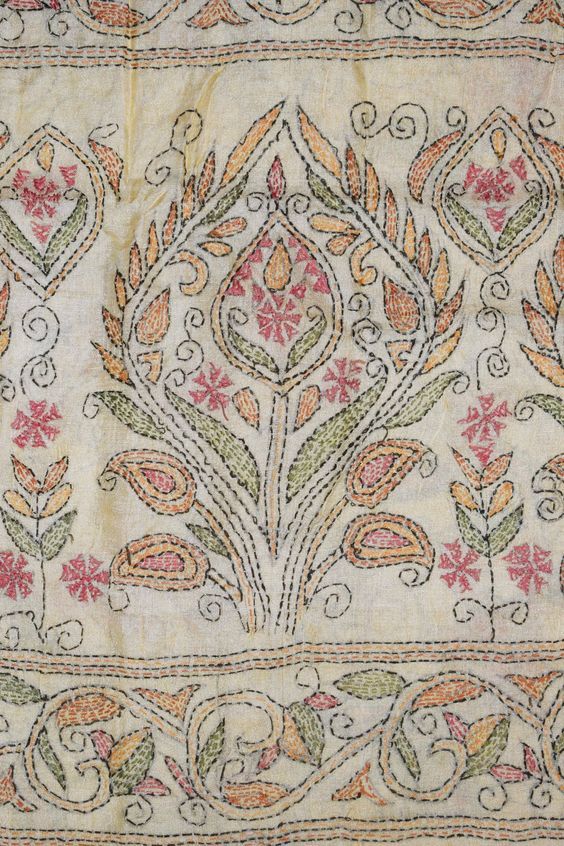 an old embroidered cloth with flowers and leaves on the edges, in various shades of pink, green, orange and yellow