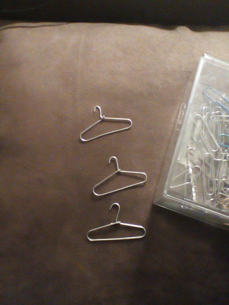 three pairs of clothes pins sitting on top of a couch next to a package of clips