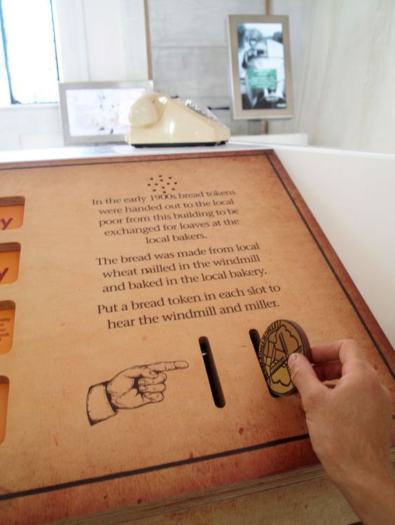 a person is pressing buttons on a wooden sign with words and pictures in the background