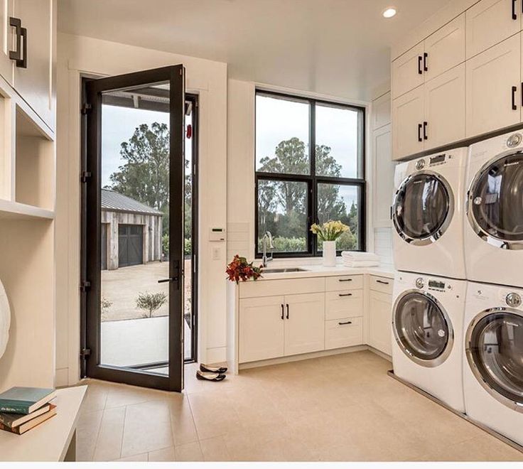 a washer and dryer in a large room with open doors leading to the outside