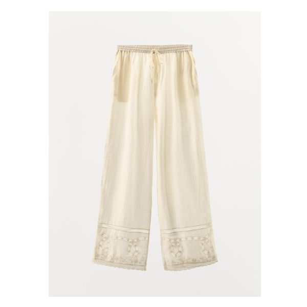 Pants made of viscose and 10% linen blend. Mid-waist shorts with elastic waistband and adjustable drawstring. Side hidden in-seam pockets. Matching tonal lace trim, embroidery and beading appliqué. Wide leg. White Bohemian Bottoms With Drawstring, Bohemian White Drawstring Bottoms, White Floral Embroidered Wide-leg Bottoms, Cream Floral Embroidery Bottoms For Summer, White Wide-leg Pants With Floral Embroidery, Summer Cream Bottoms With Floral Embroidery, Beige Cotton Pants With Floral Embroidery, Summer Floral Embroidery Cream Bottoms, White Cotton Bottoms With Embroidered Hem