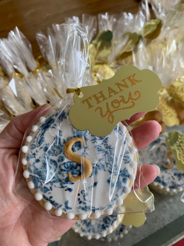 a hand holding a cookie with the word thank you on it