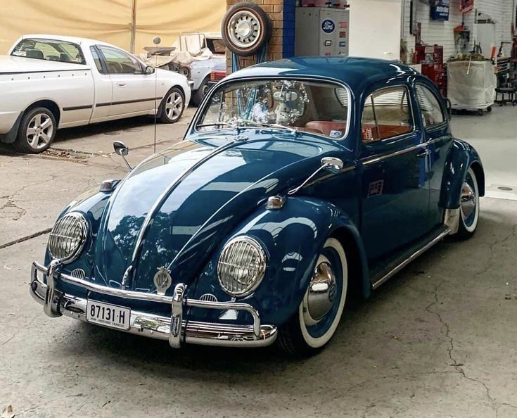 an old blue beetle parked in a garage