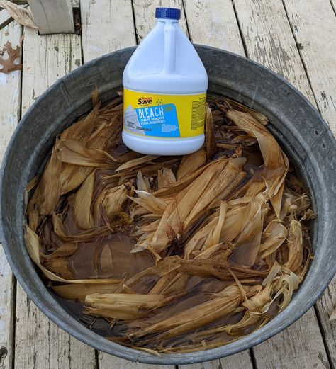 a bottle of deodorant sits in a bucket full of wood shavings