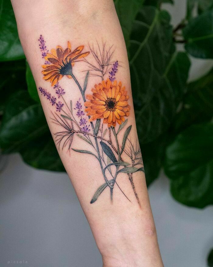 a woman's arm with an orange and purple flower tattoo on the left forearm