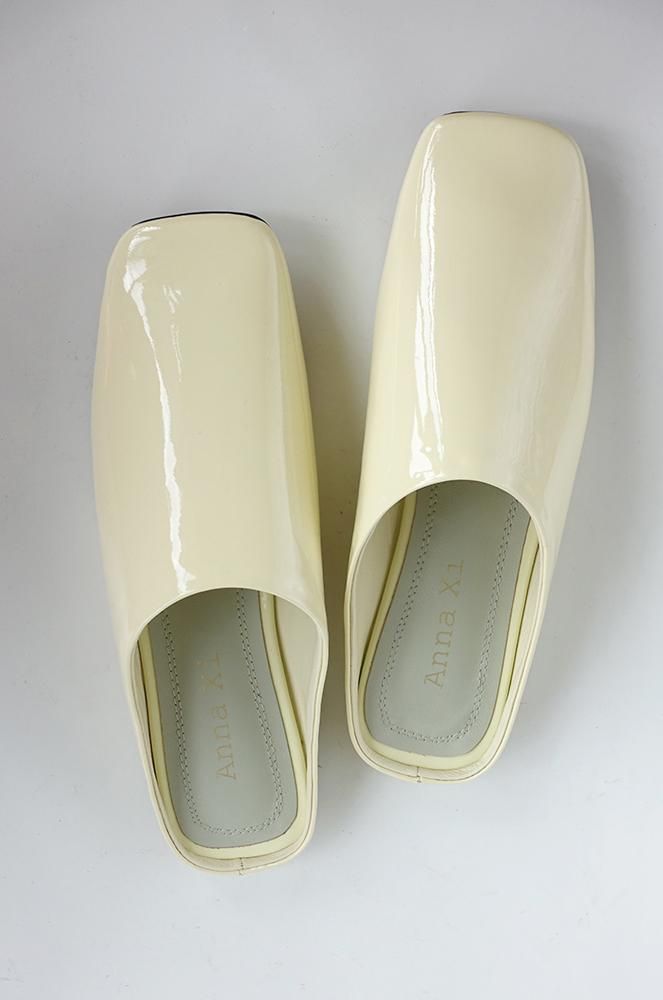 Spring yellow patent leather slippers made of real leather. Get them for a chic and comfy look! Sleek Patent Leather Mules For Summer, Cream Patent Leather Sandals For Spring, Modern Patent Leather Slip-on Sandals, Elegant White Summer Clogs, Summer Patent Leather Slip-on Mules, Spring Patent Leather Slip-on Mules, Summer Patent Leather Mules With Round Toe, Summer Patent Leather Closed Toe Mules, Yellow Flat Mules For Spring