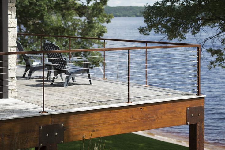 a deck overlooking the water with chairs on it