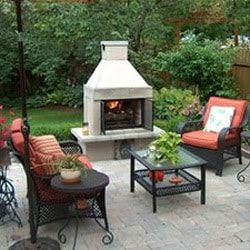 an outdoor patio with chairs, table and fire place