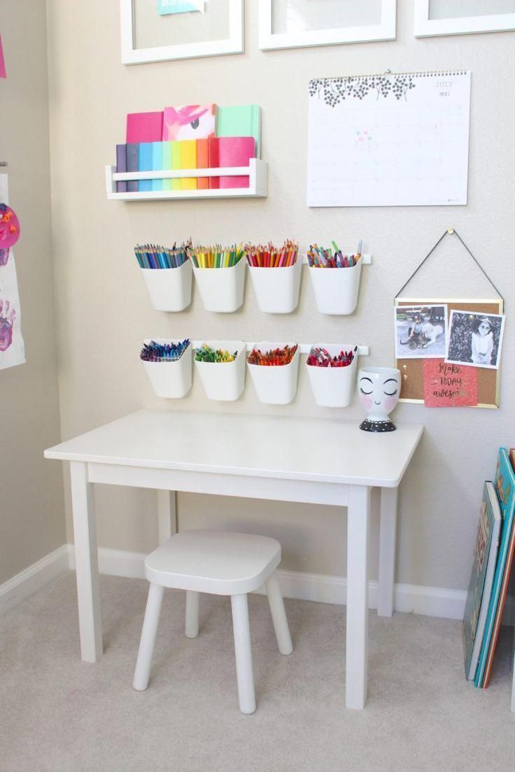 a white table topped with lots of cups filled with crayons