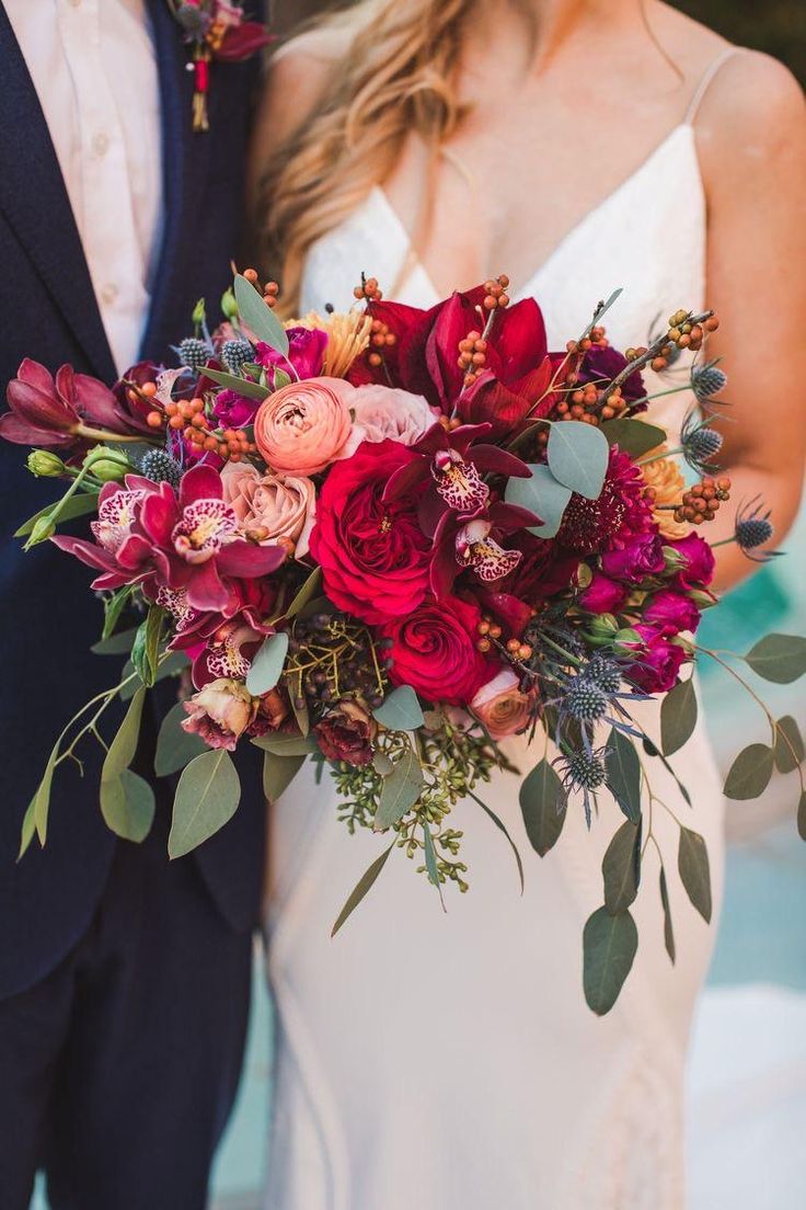 a bride and groom holding a bouquet of flowers