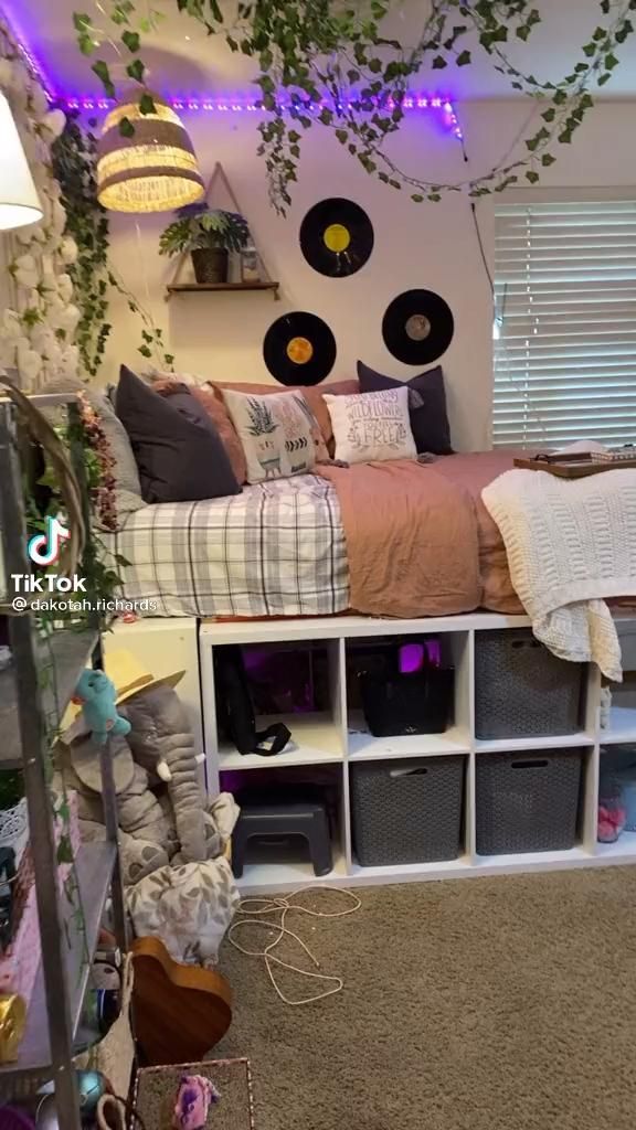 a bed with lots of pillows and blankets on top of it in a room filled with furniture