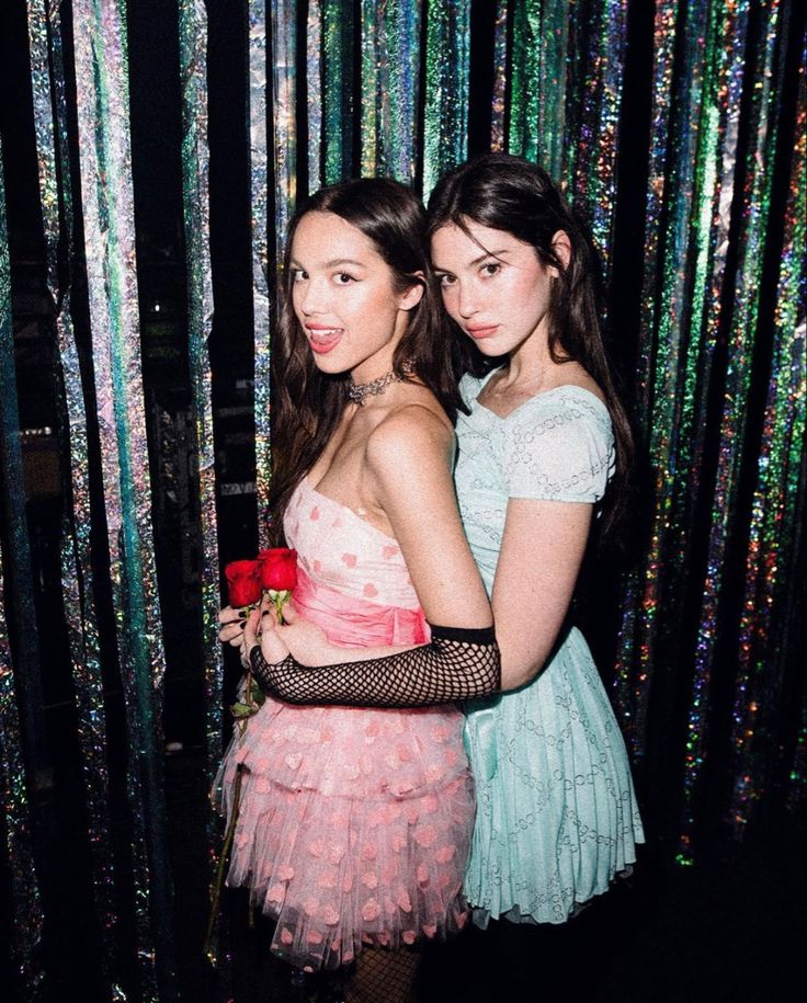 two young women standing next to each other in front of sequins and trees