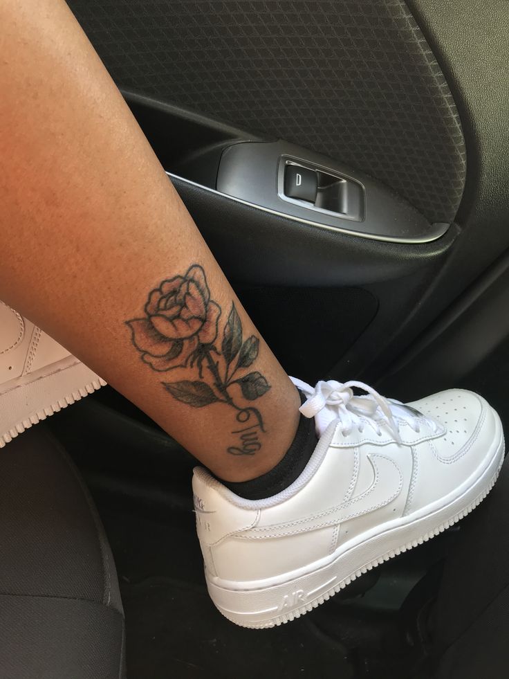 a woman's foot with a rose tattoo on the side of her left leg