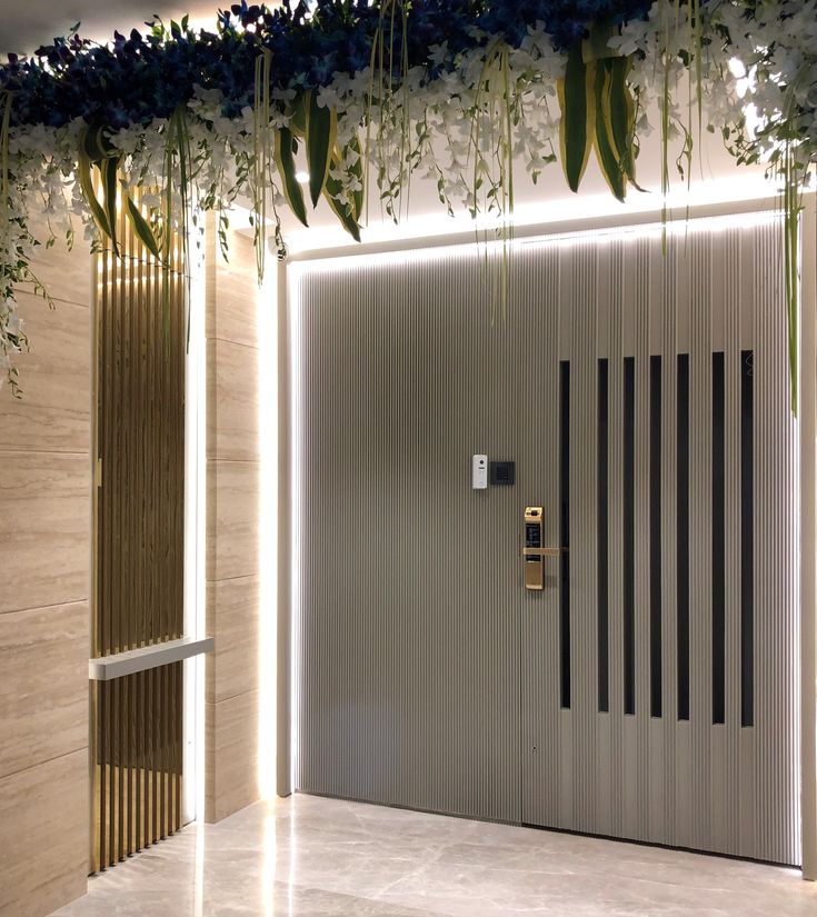 the entrance to an office building is decorated with flowers and greenery hanging from the ceiling