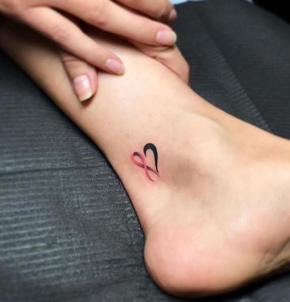 a woman's foot with a small tattoo on the left side of her leg