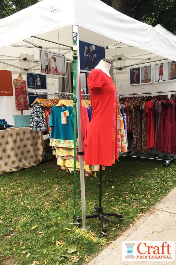 a tent with clothes on display in the grass