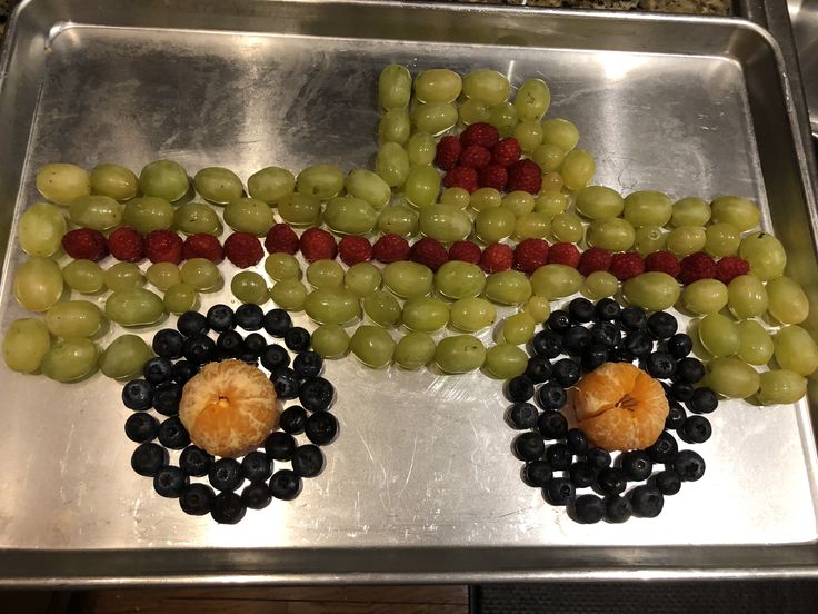 grapes, raspberries and other fruit arranged in the shape of a truck