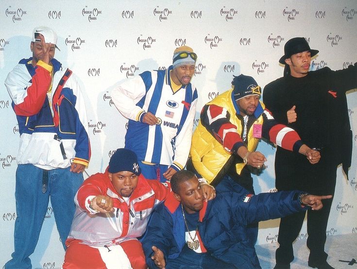 the men are posing together in front of a wall with an american flag on it