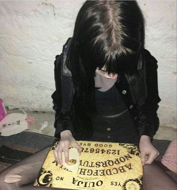 a woman sitting on the floor cutting into a cake with yellow frosting and writing on it